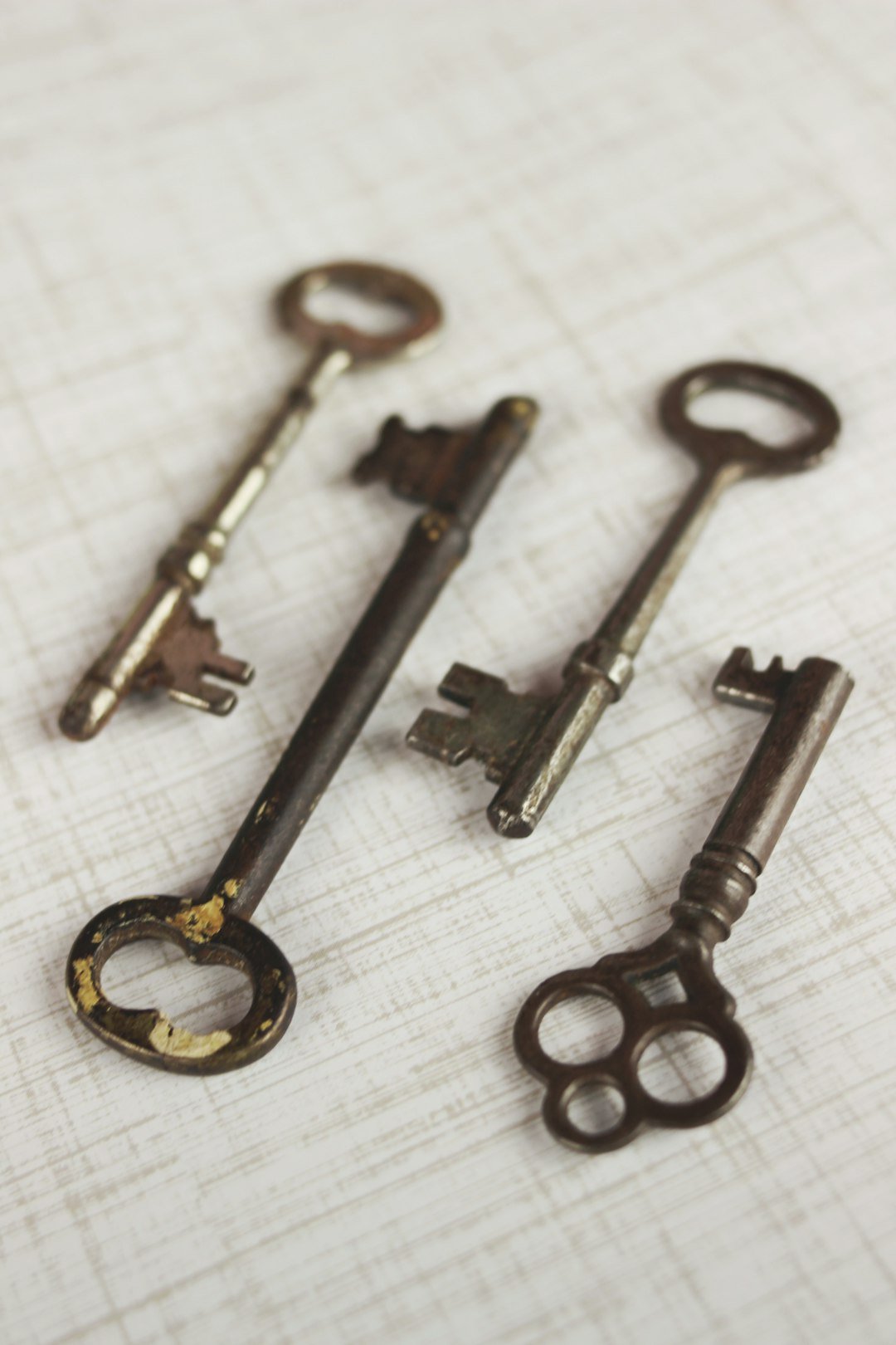 Set of four brass vintage skeleton keys on neutral background. Very steampunk look!